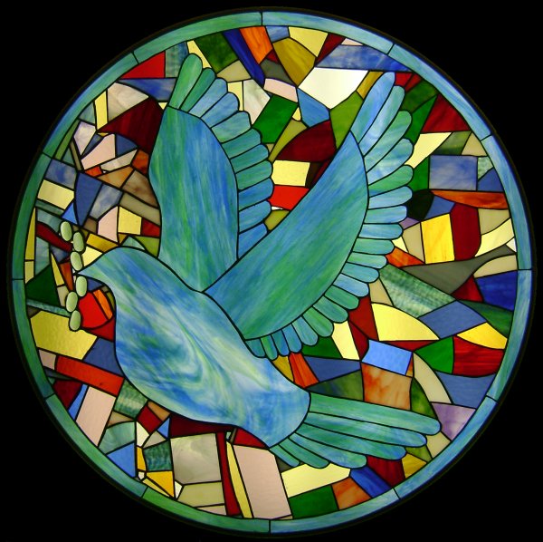 Stained glass window of large marbelized sky blue and turquoise dove encircled by multicolored diverse sized blocks of dark red, blue, yellow, gray, lavender, brown, and green.